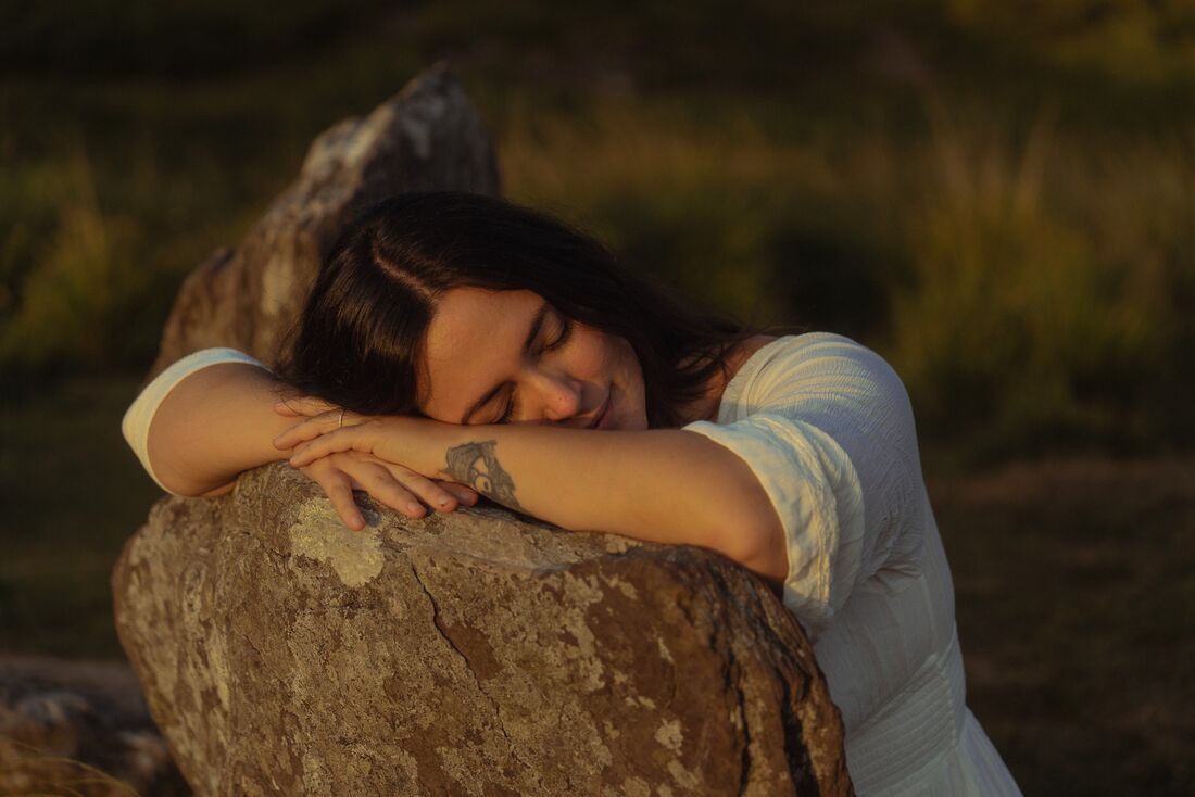 Natalie resting against a stone