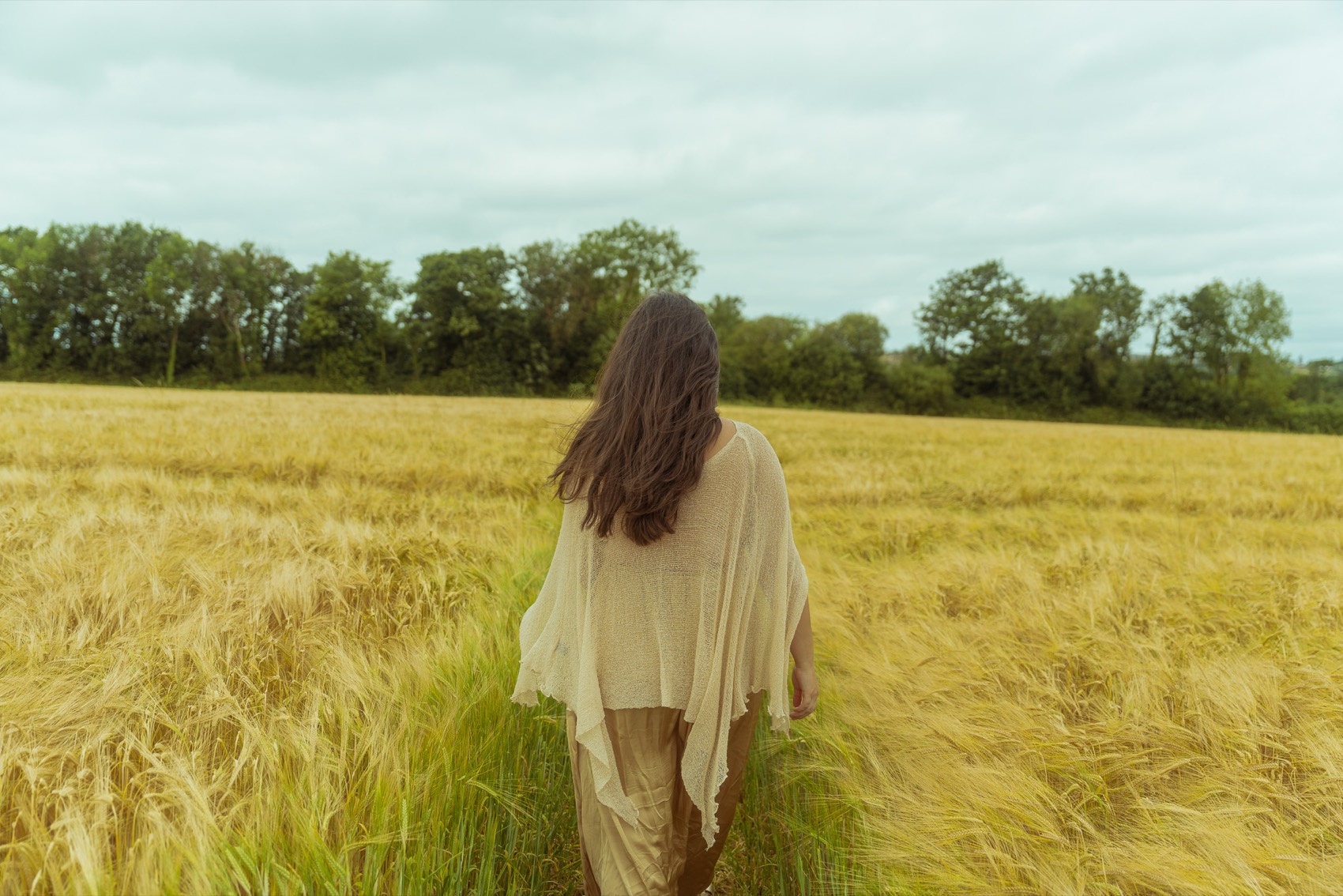 Natalie walking through a golden wheat field