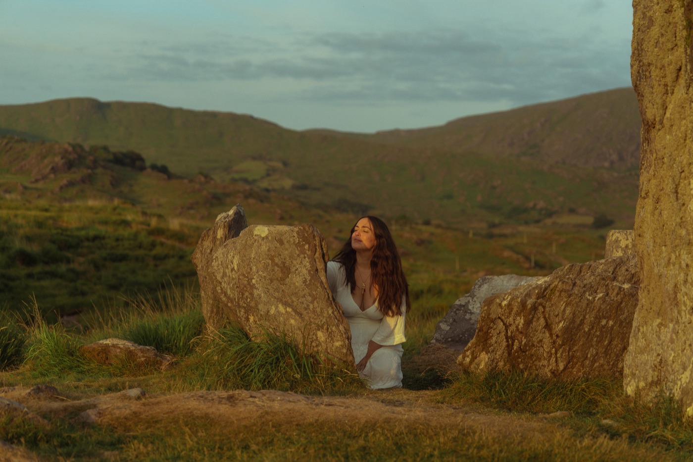 Natalie resting against an ancient standing stone